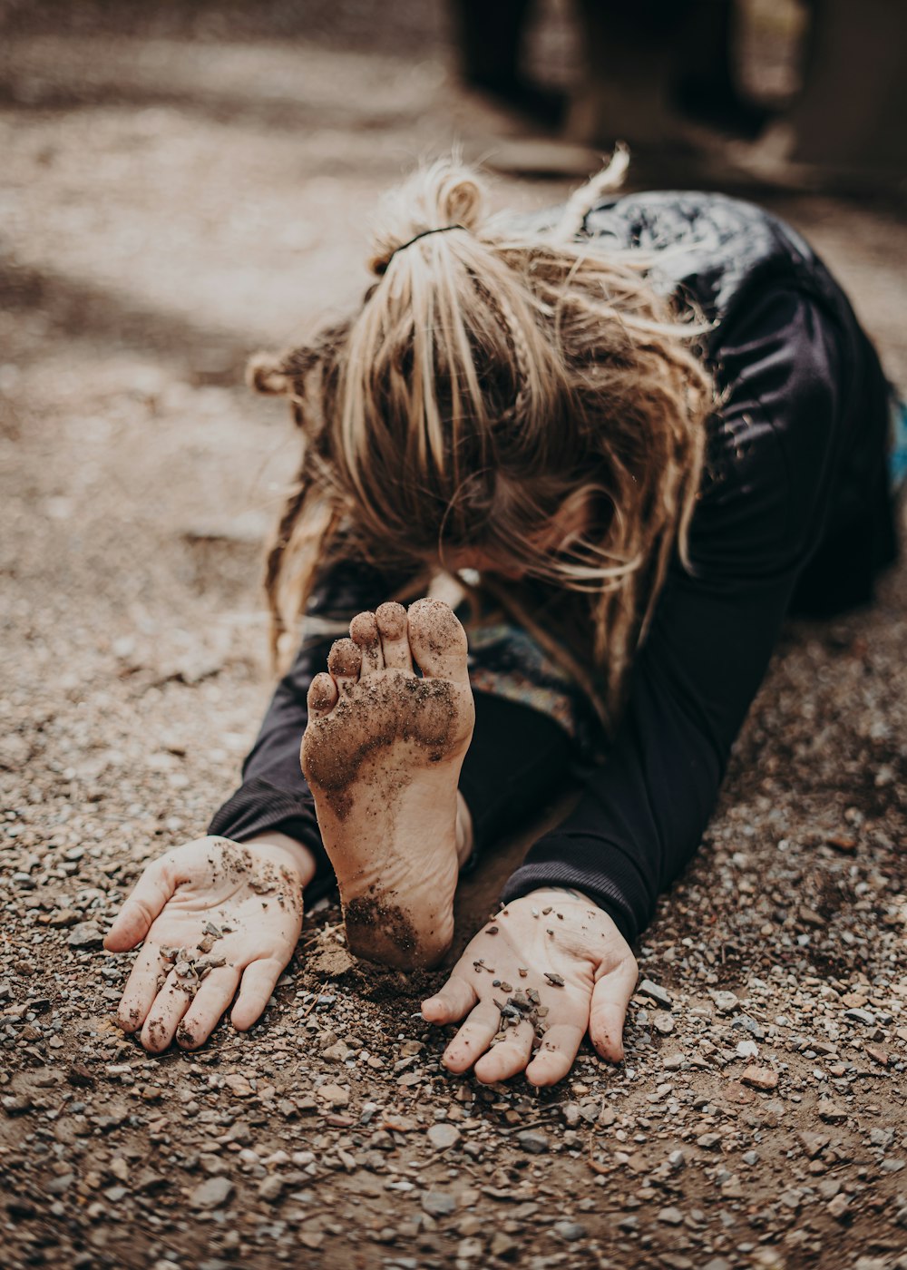 une femme allongée sur le sol couverte de terre