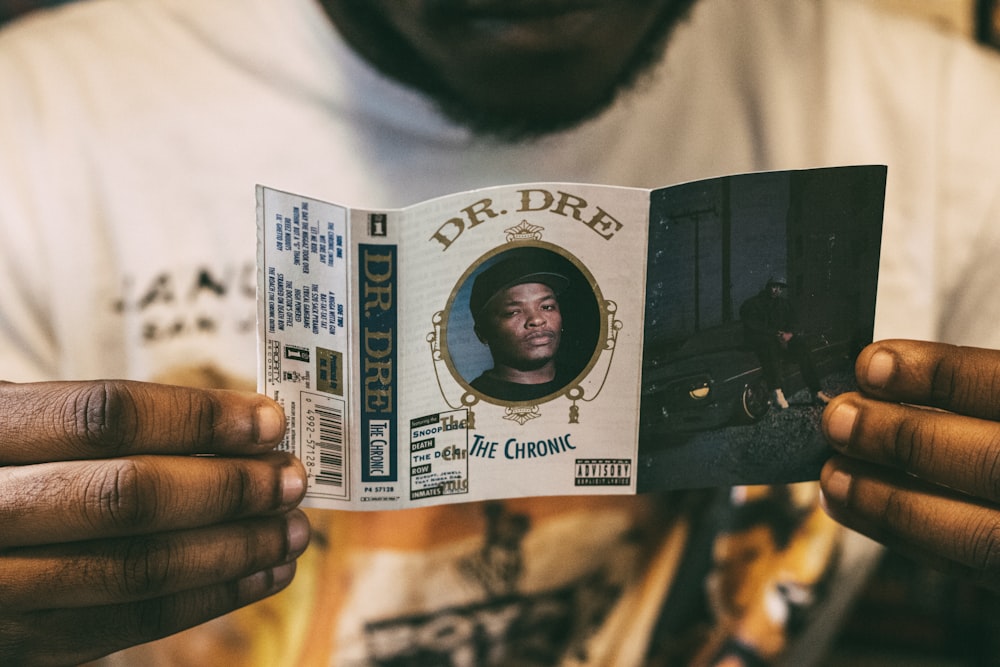 a man holding up a book with a picture of a man on it