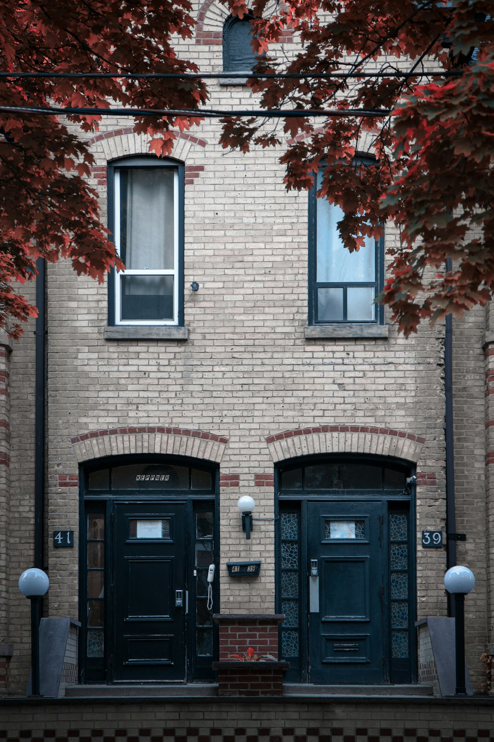 a brick building with two black doors and windows