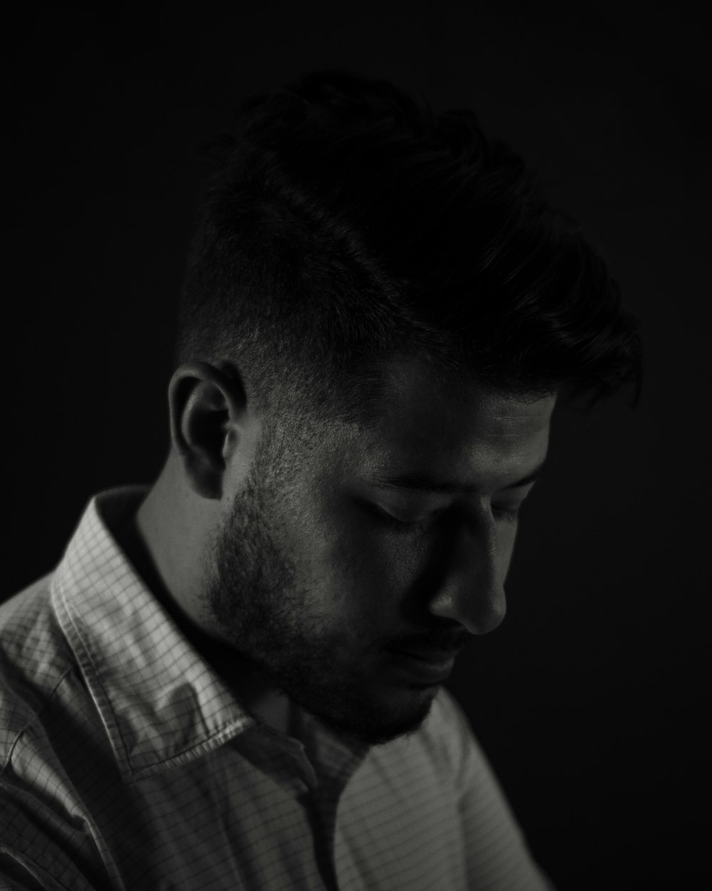 a man in a shirt and tie looking down