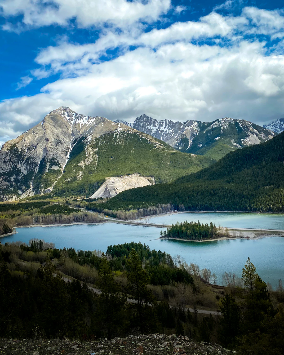 Island Lake in Crowsnest Pass, with a wooded islet, below rocky peaks