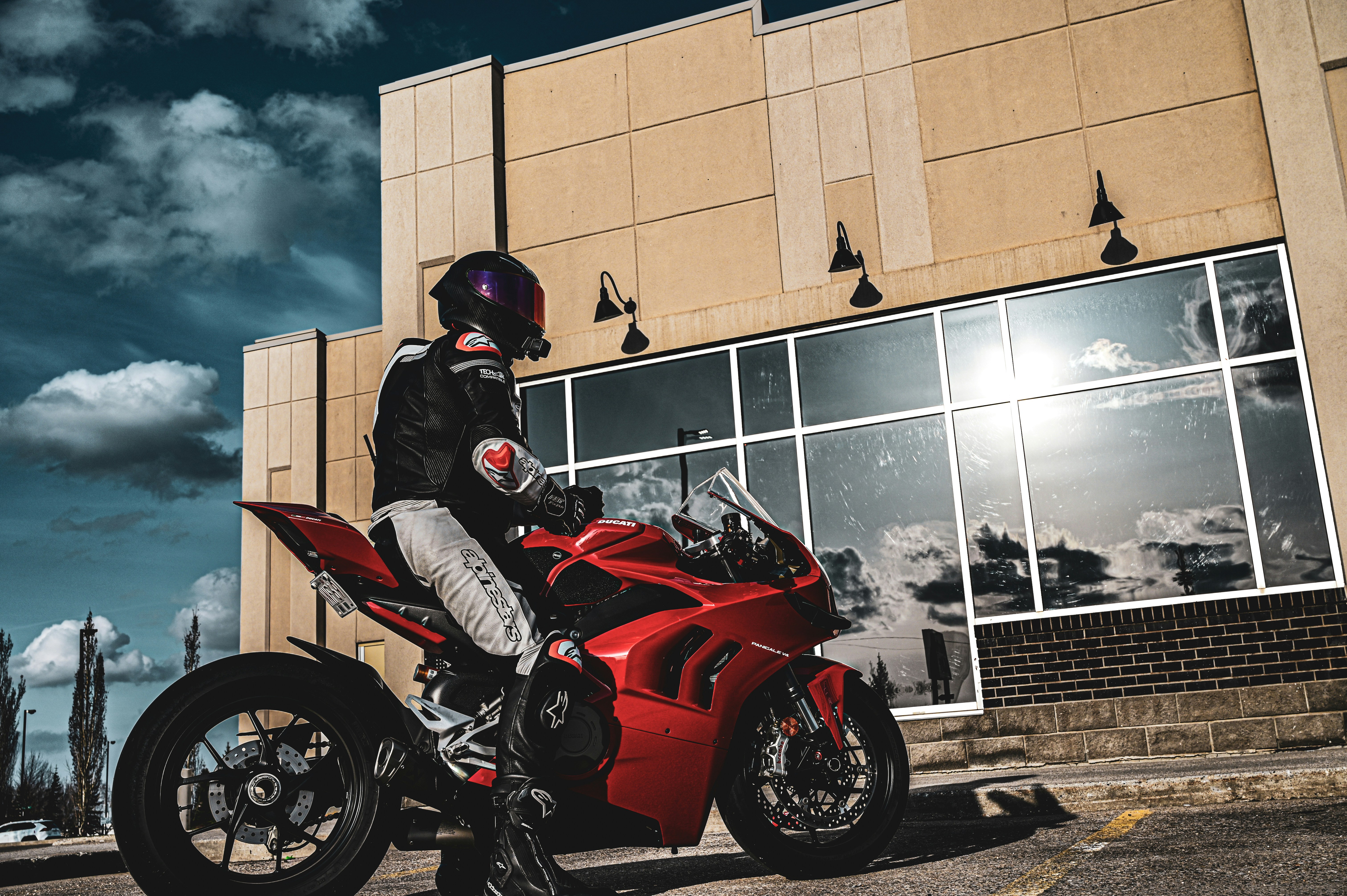 a person on a red motorcycle in front of a building