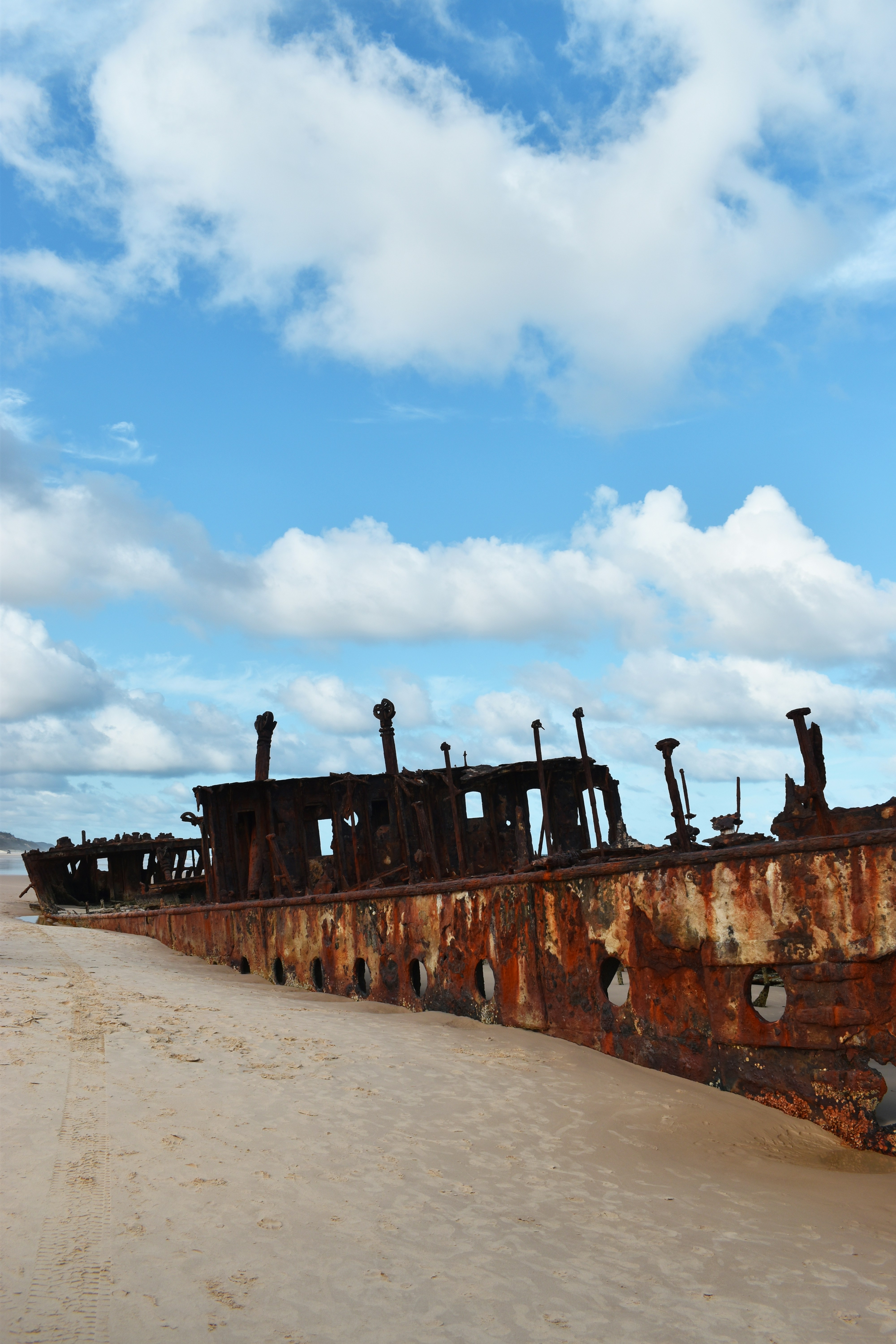 A rusted ship sitting on top of a sandy beach photo – Free Blue Image ...