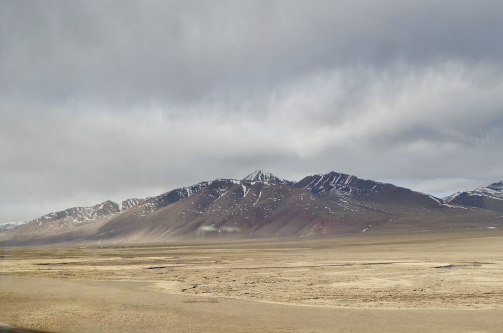 the mountains are covered in snow on a cloudy day