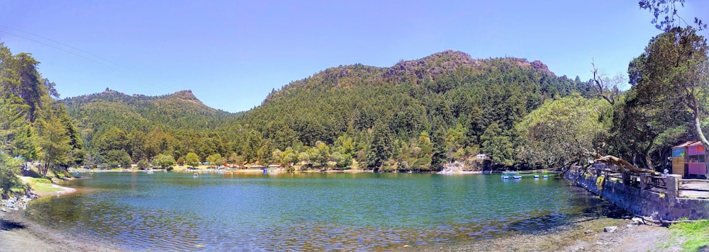 um corpo de água cercado por árvores e montanhas