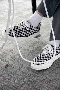 a person wearing black and white checkered shoes