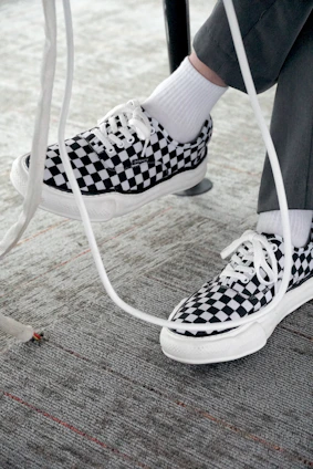 a person wearing black and white checkered shoes