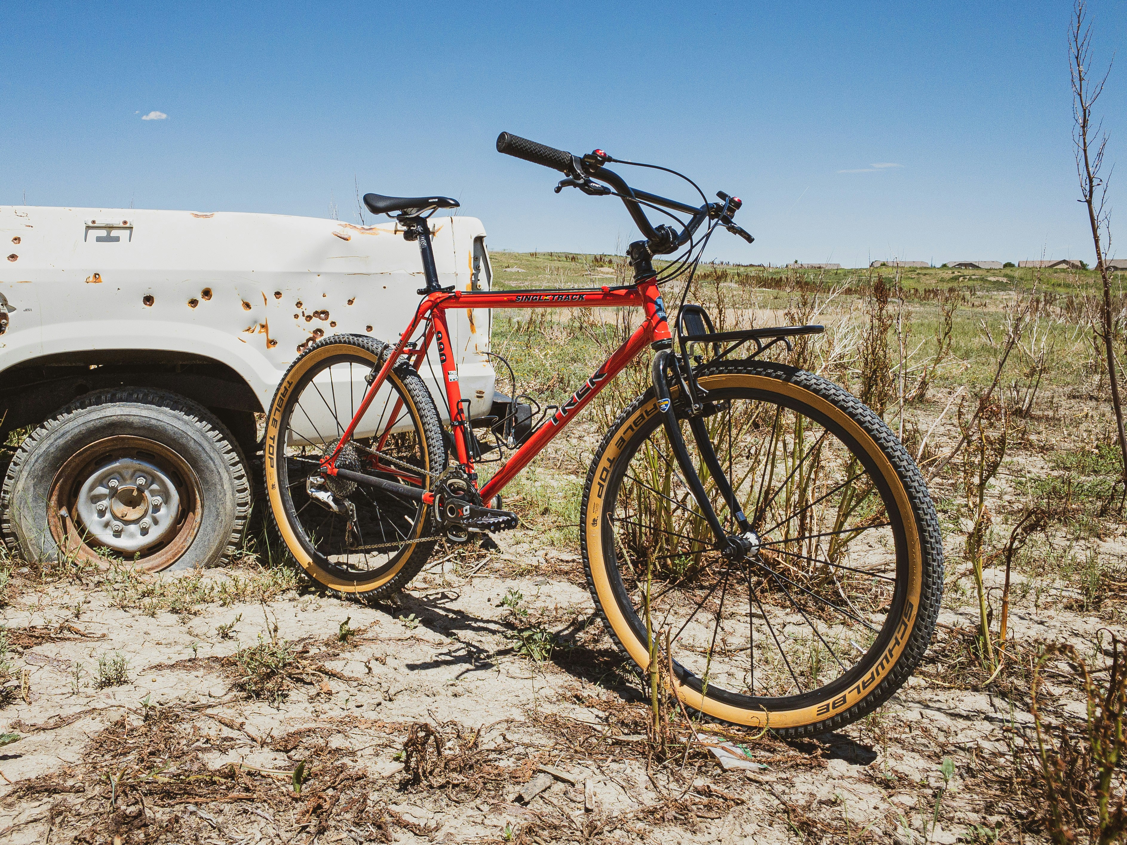 a red bike is parked next to a white truck