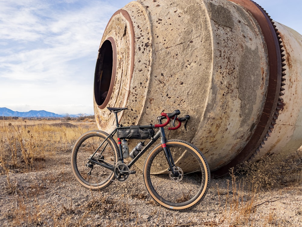 Una bicicleta está estacionada junto a un barril grande