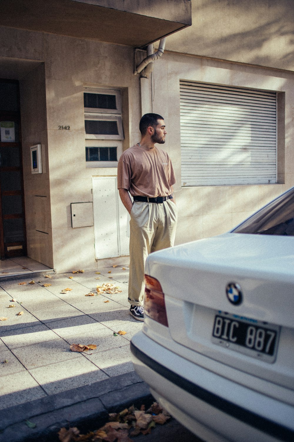 a man standing in front of a white car