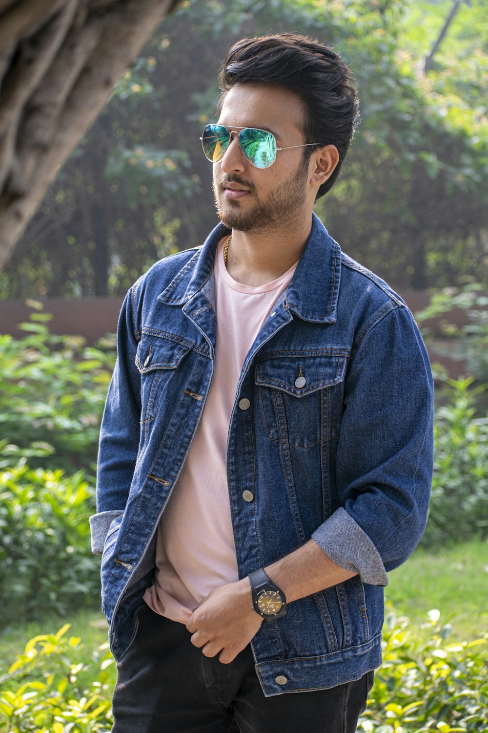 a man wearing a jean jacket and sunglasses