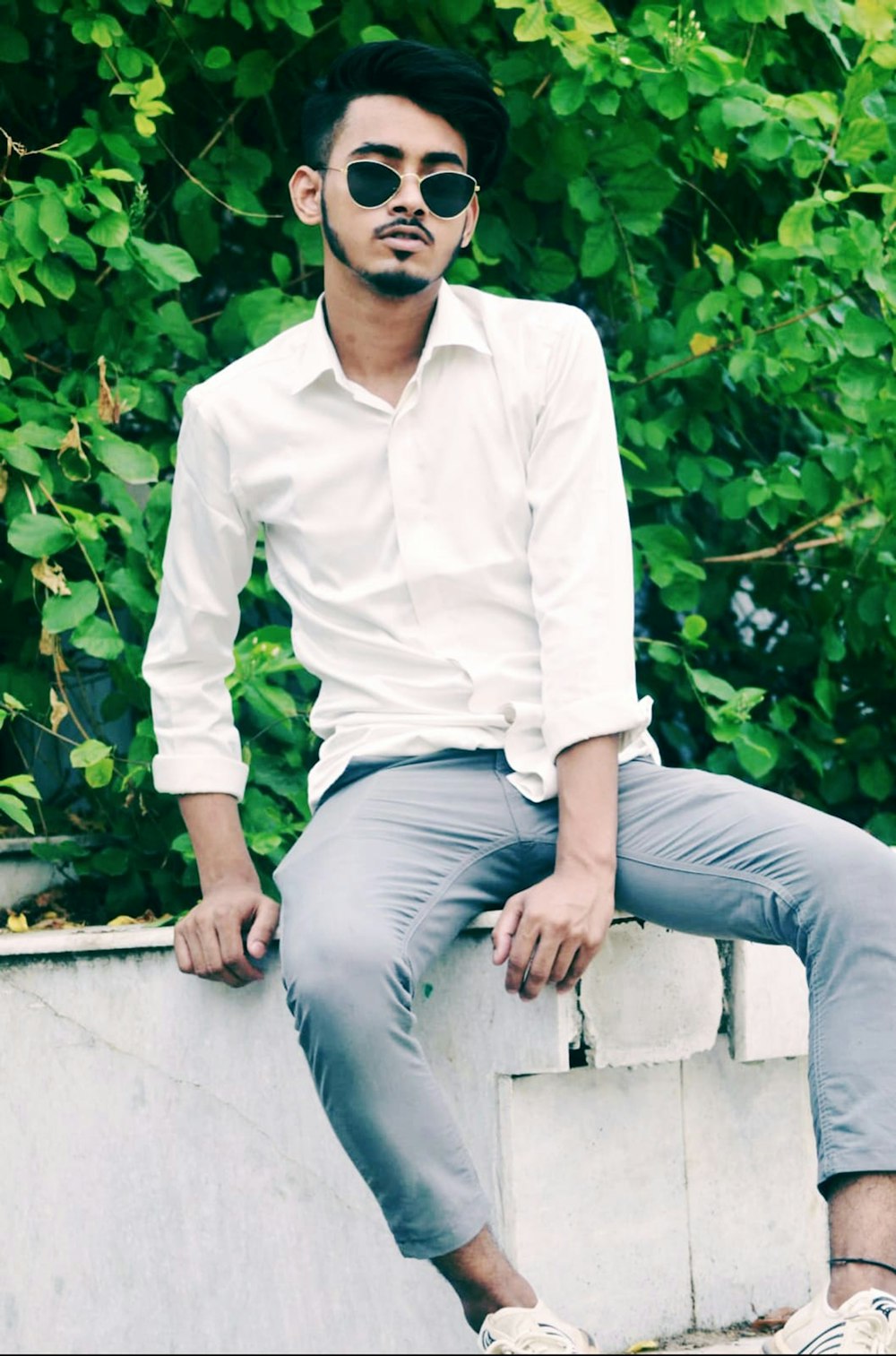 a man sitting on top of a cement wall