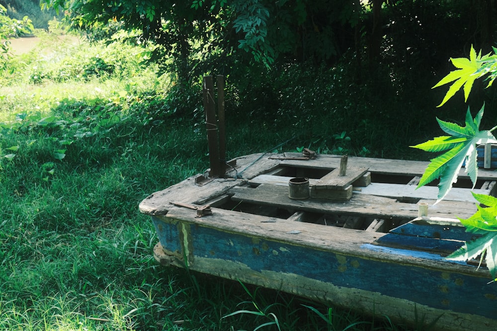 an old wooden boat sitting in the grass