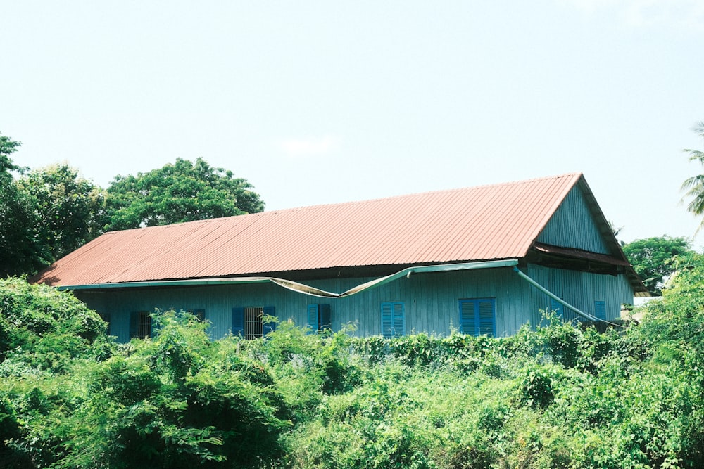 a blue house surrounded by trees and bushes