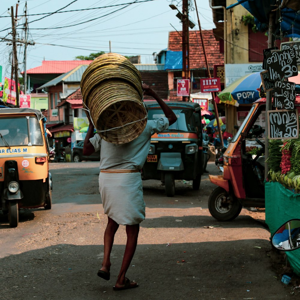 a woman carrying a large bundle down a street