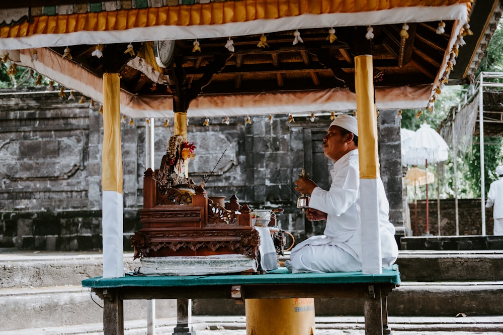 a man sitting at a table in front of a cake