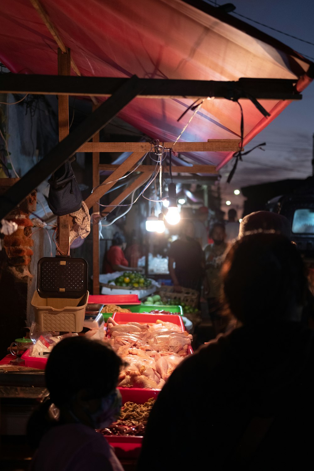 a group of people standing around a table filled with food