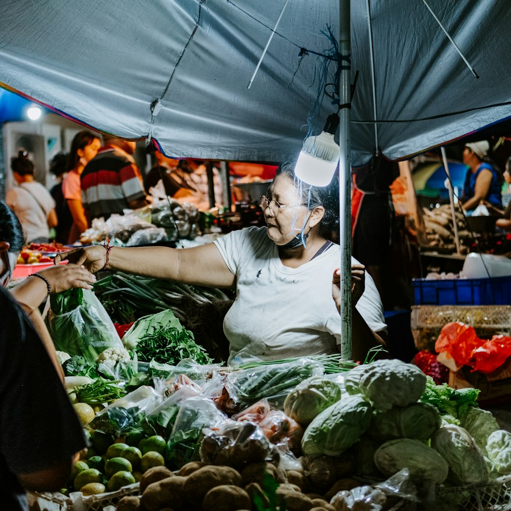 a man standing in front of a table filled with fruits and vegetables