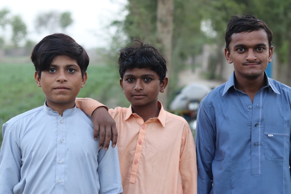 a group of three boys standing next to each other