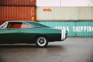 A sleek American car being unloaded from a shipping container at a port.