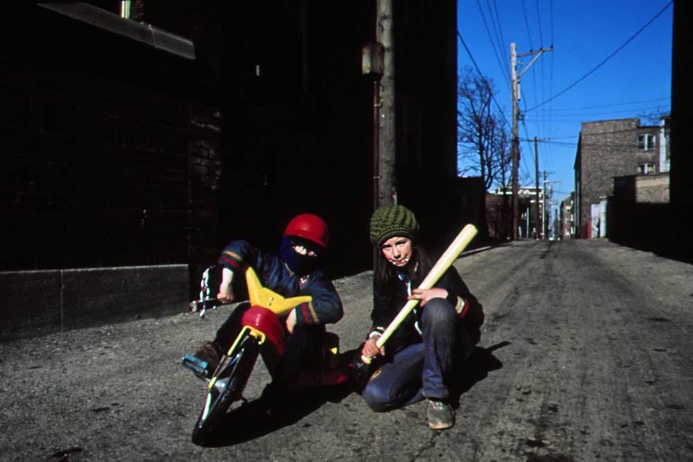 a couple of people sitting on the side of a road