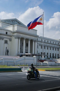 a person riding a motorcycle in front of a building