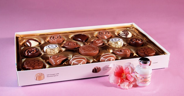 a box of chocolates with a pink flower