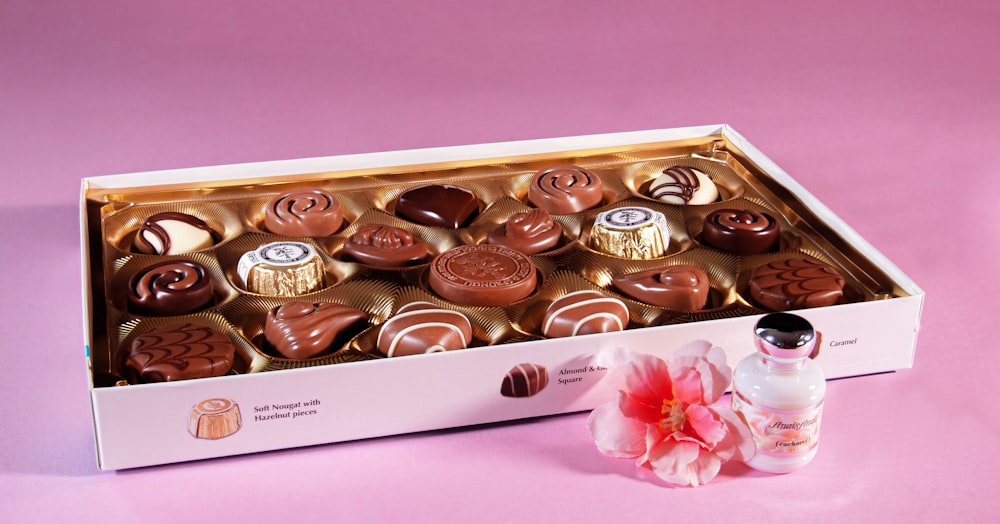 a box of chocolates with a pink flower