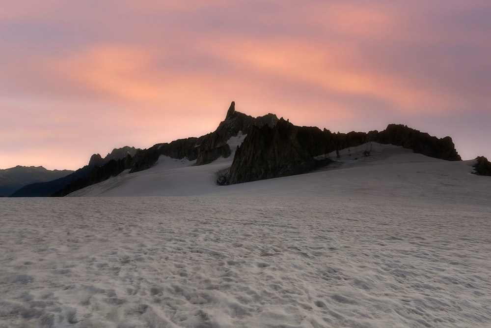 a snow covered mountain with a pink sky in the background