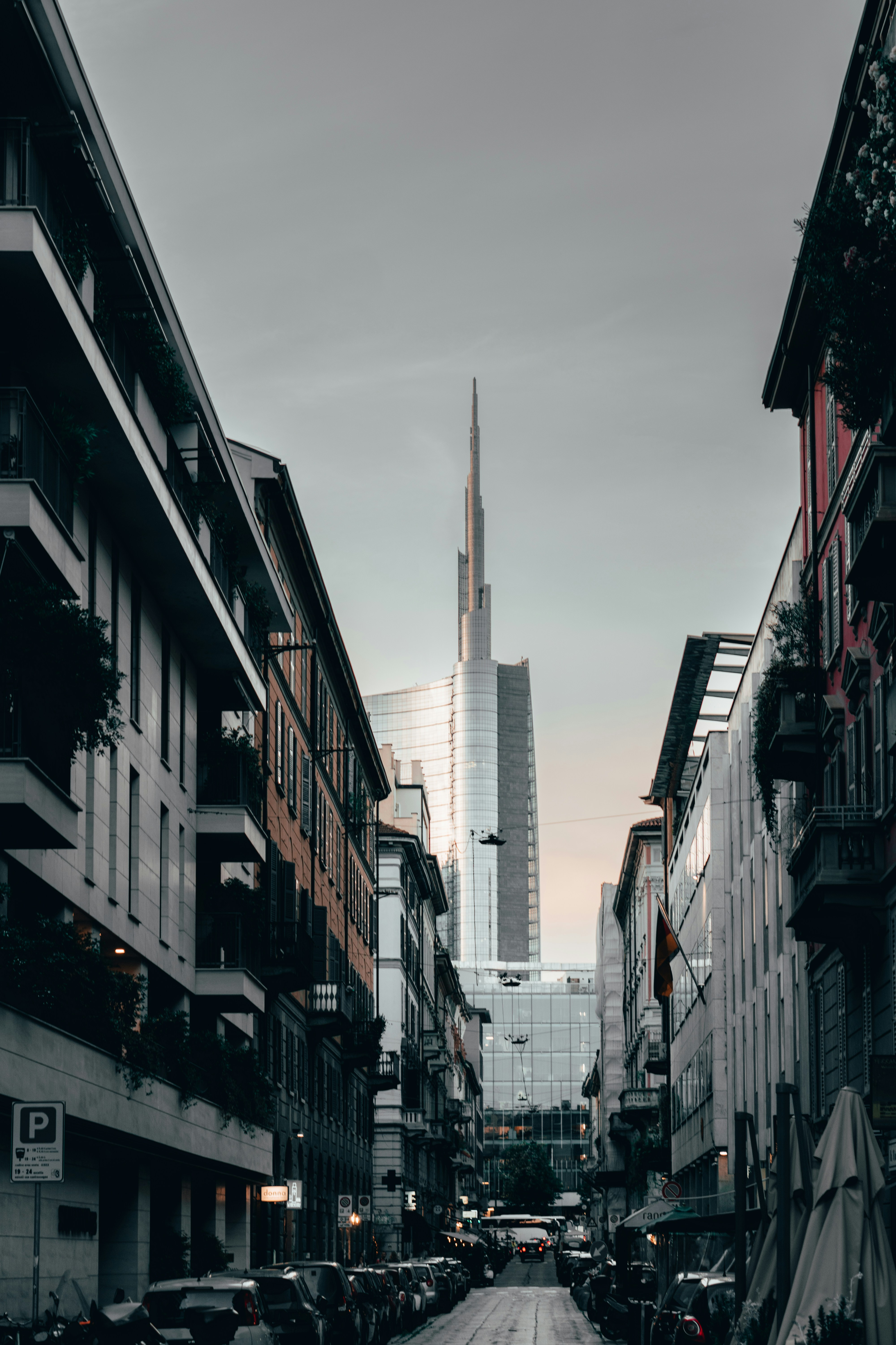 a city street lined with tall buildings and parked cars