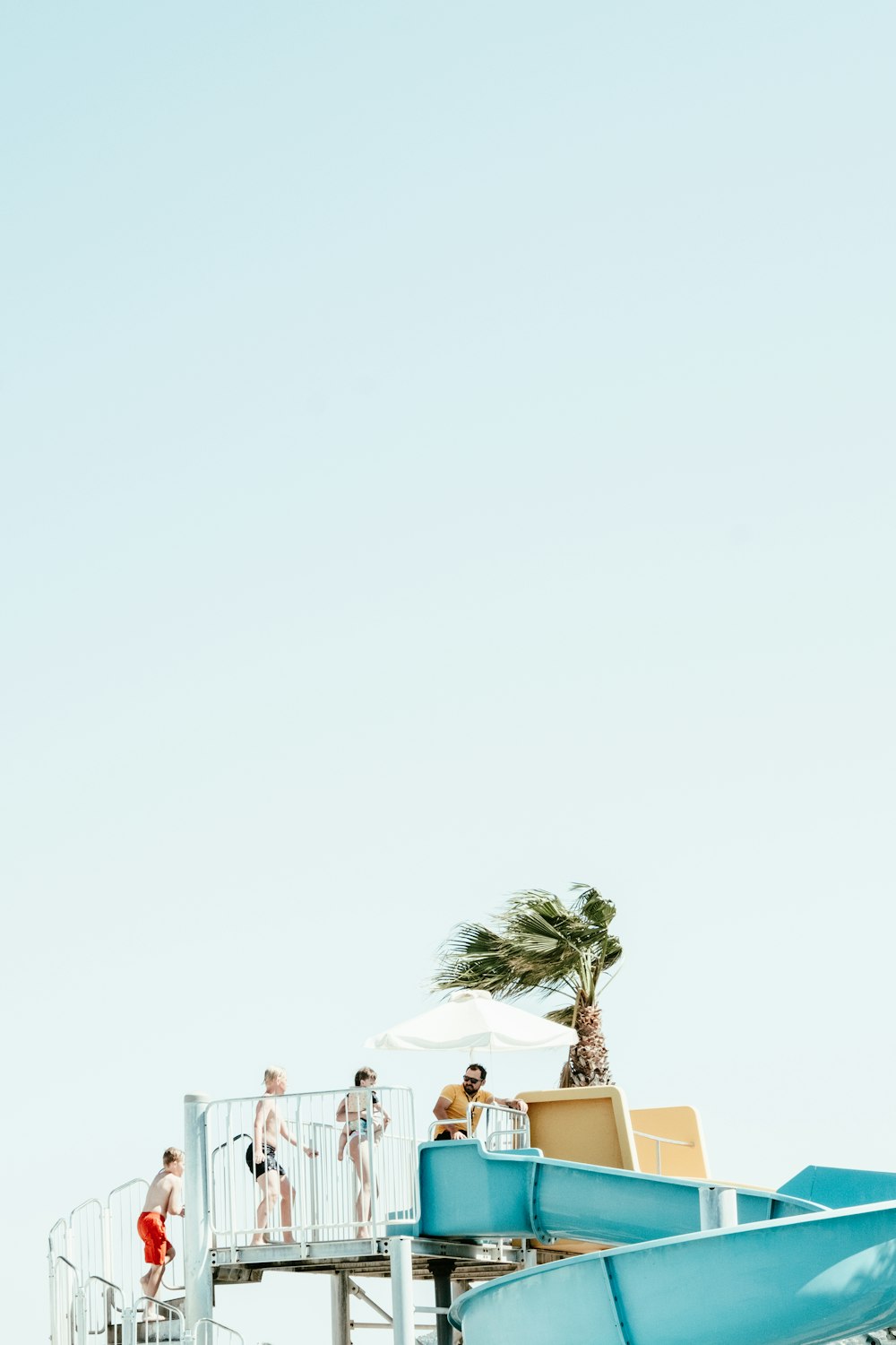 a group of people standing on top of a water slide