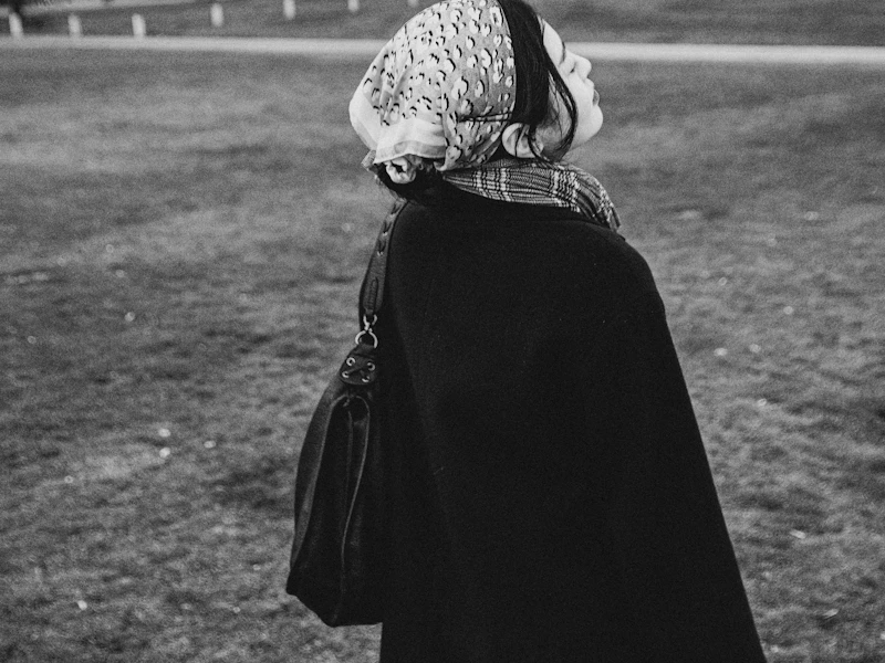a black and white photo of a woman in a park