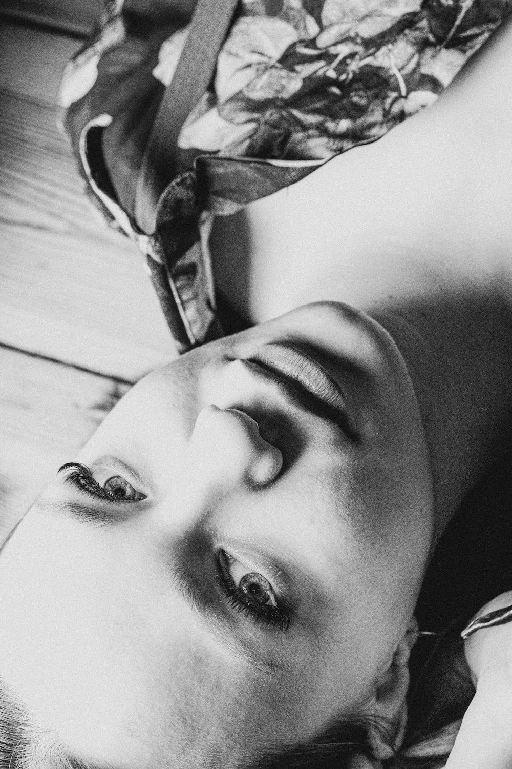 a black and white photo of a woman laying on the floor