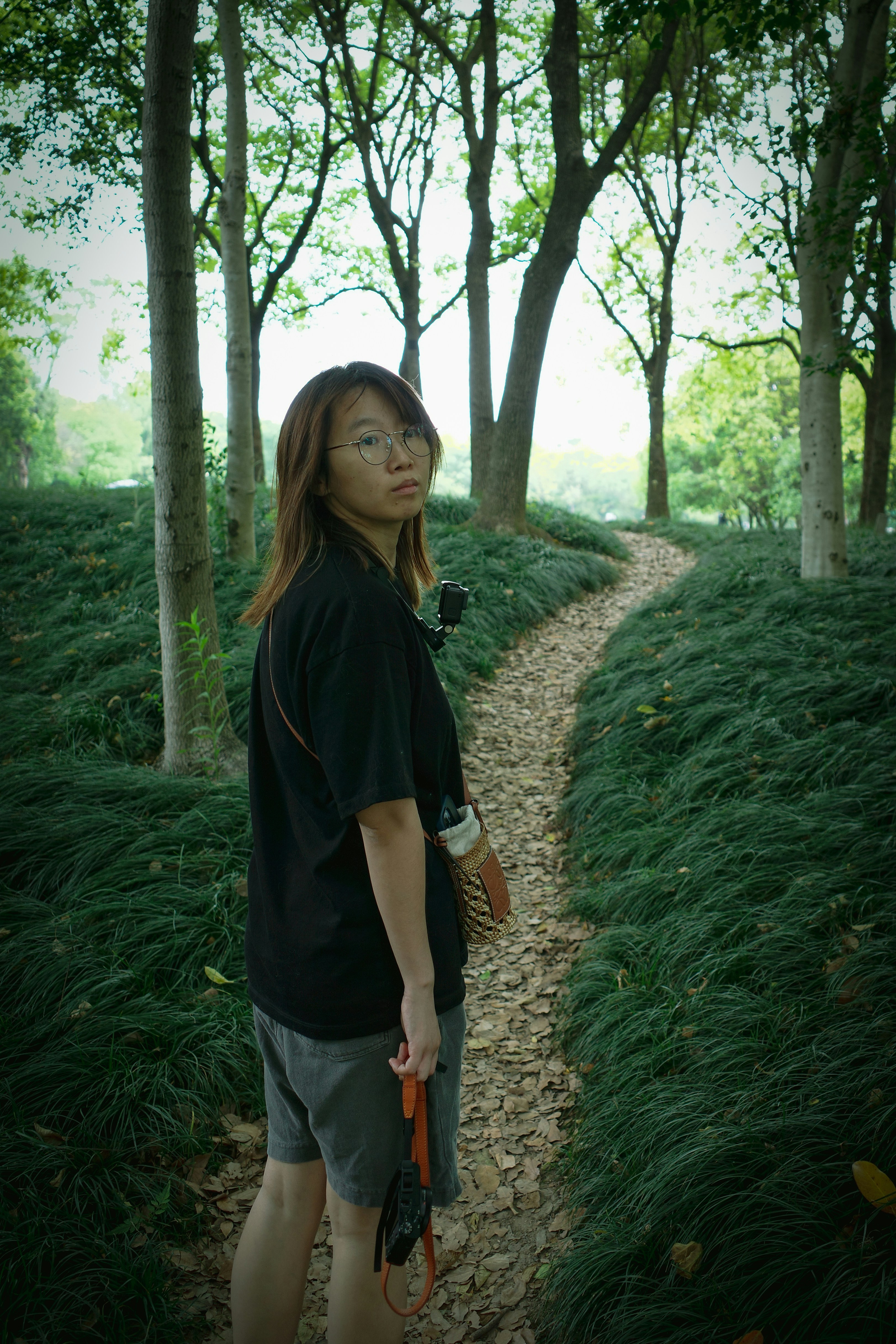 A woman standing on a path in the woods photo – Free Human Image on ...