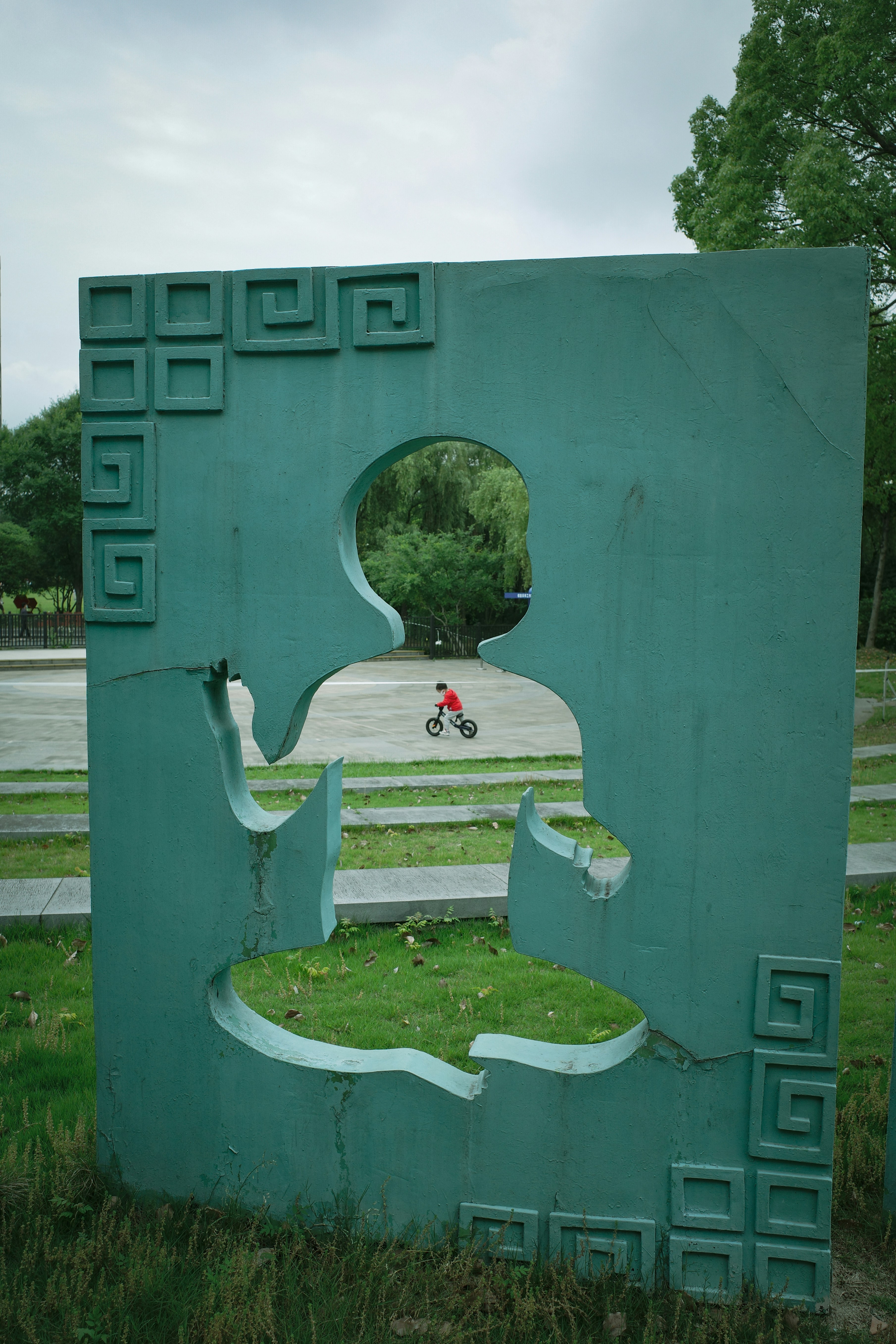 a sculpture of a person on a bike in a park