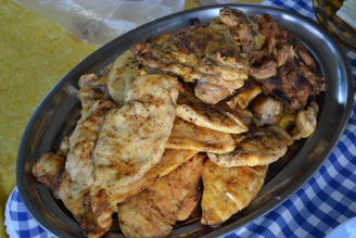 An elegant platter of assorted premium chicken cuts, seasoned and ready for the BBQ, set against a charcoal background.