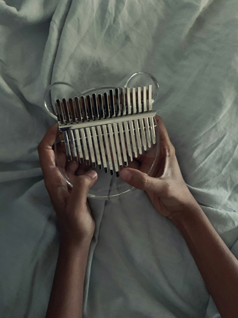 a person is holding a musical instrument on a bed