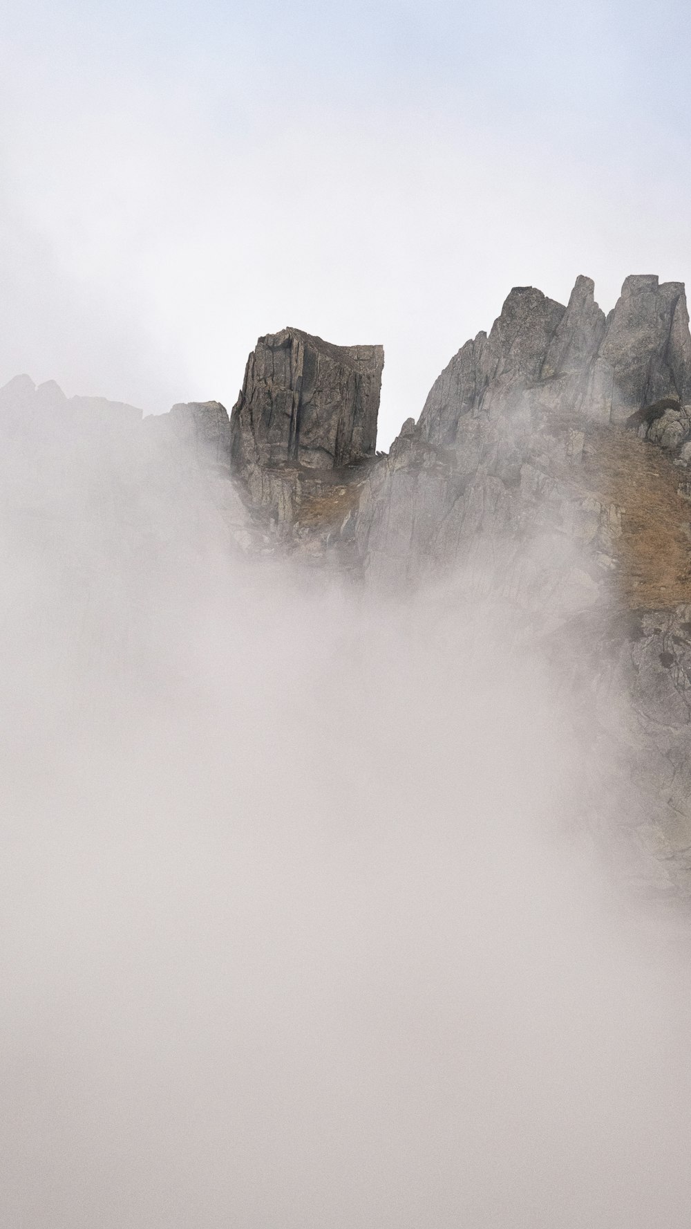 Una montagna coperta di nebbia con una persona su un cavallo