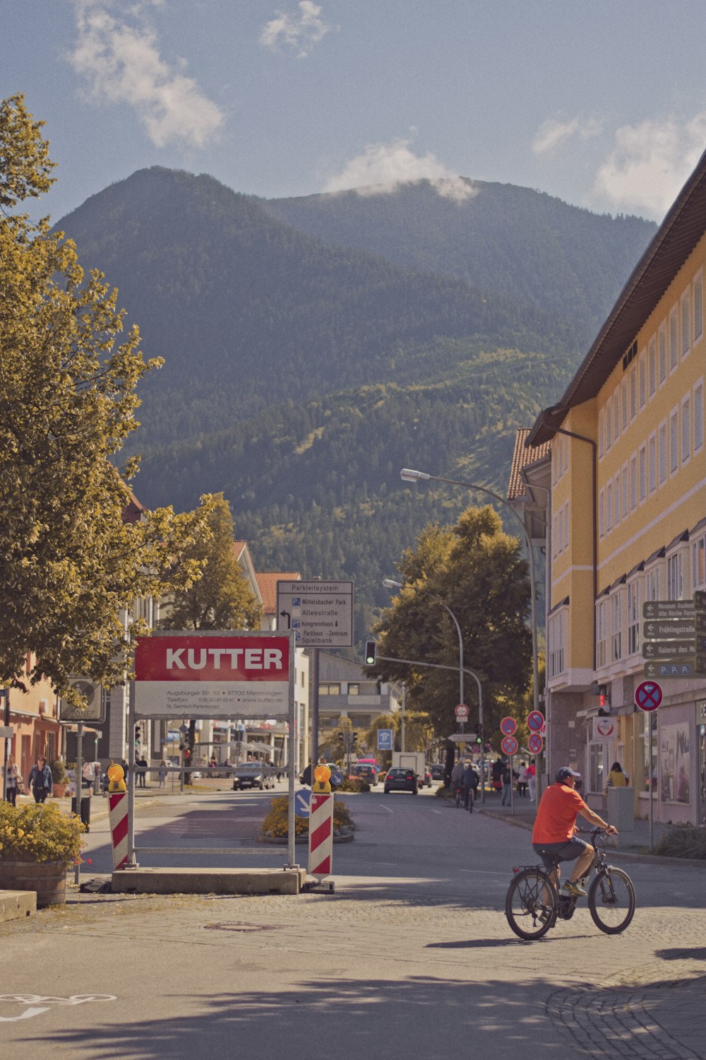 a man riding a bike down a street next to tall buildings