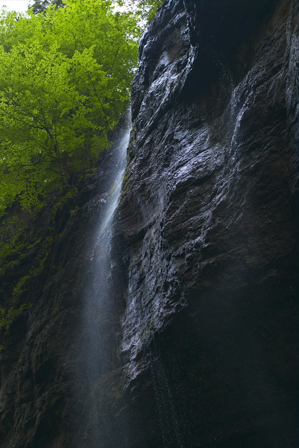 a waterfall with a waterfall cascading down the side of it