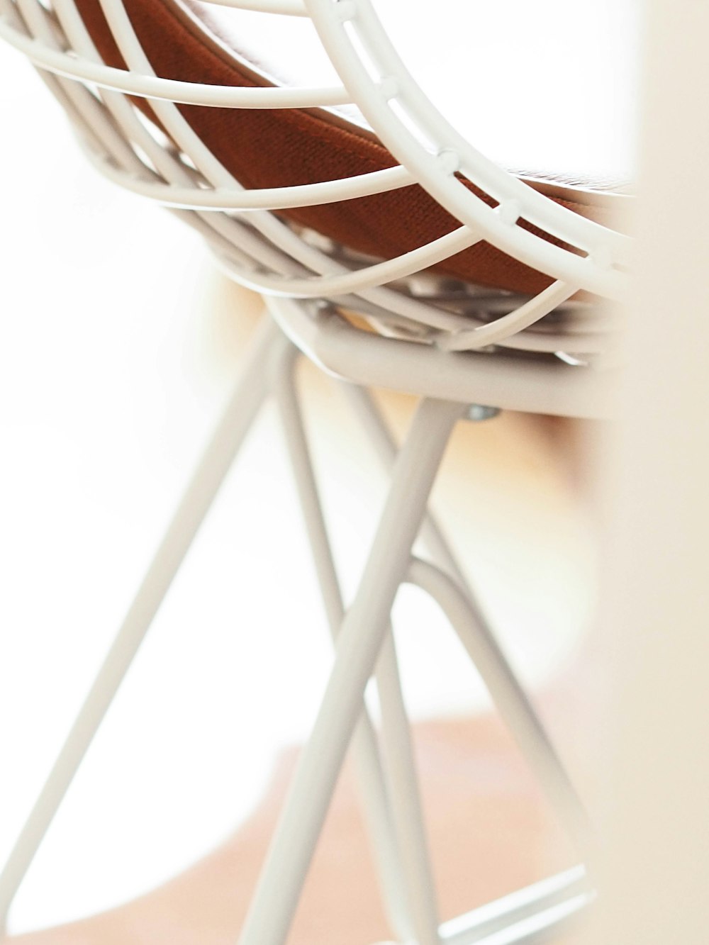 a close up of a white chair with a wooden seat