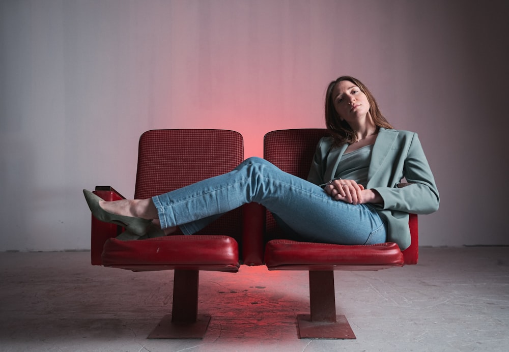 a woman sitting on a red chair with her legs crossed