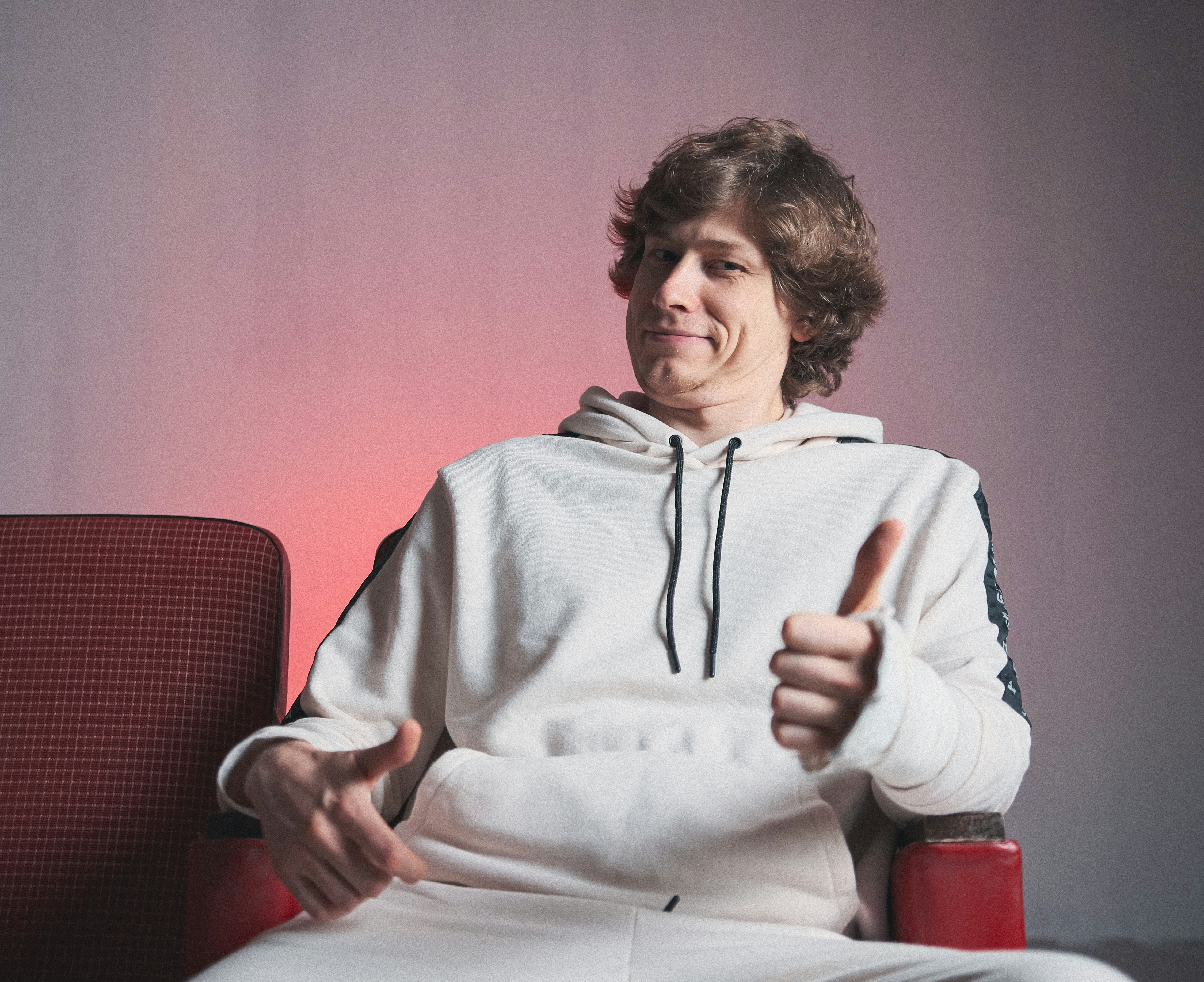 a man sitting on a red chair with a thumbs up