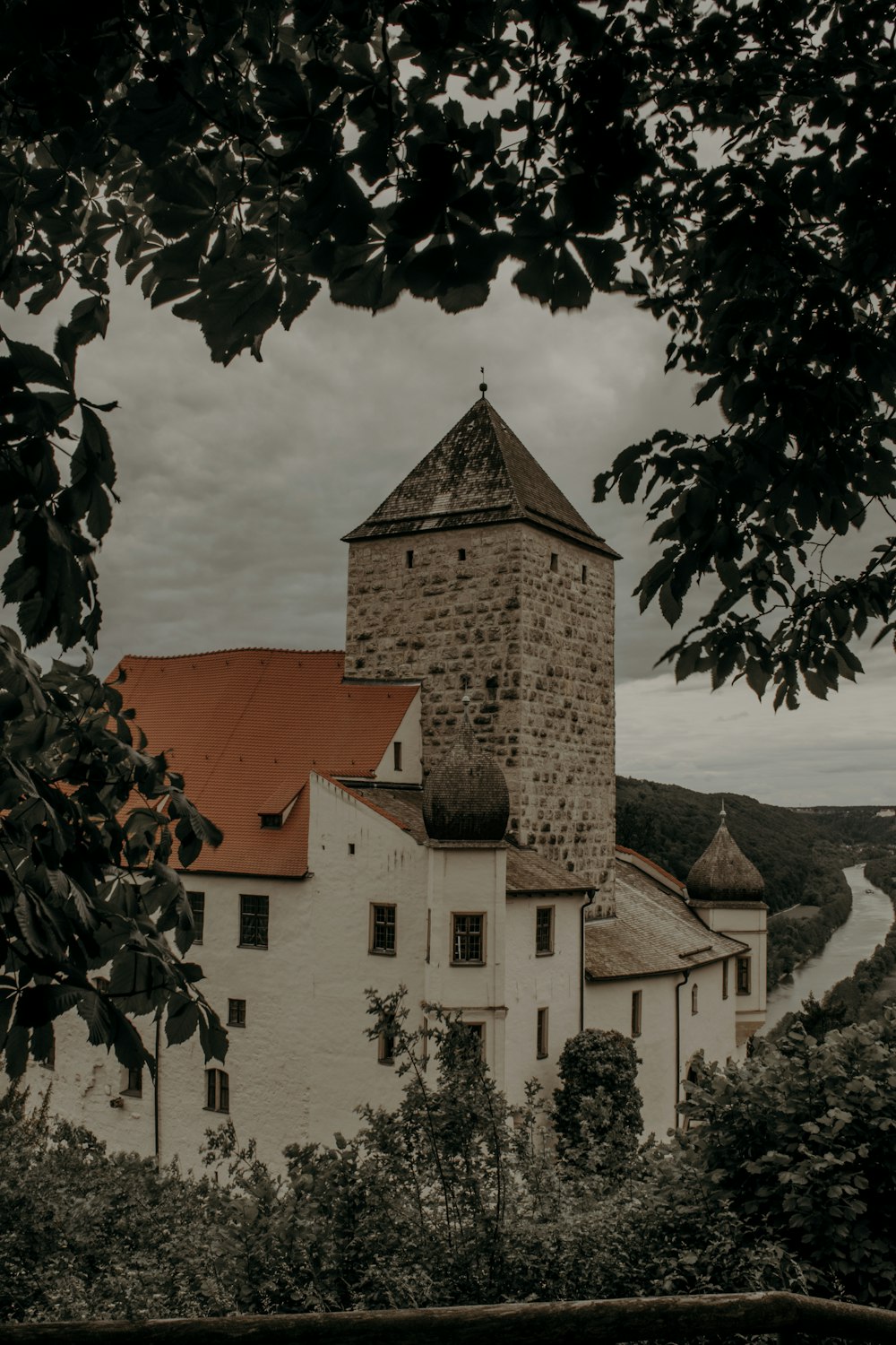 a white building with a red roof surrounded by trees