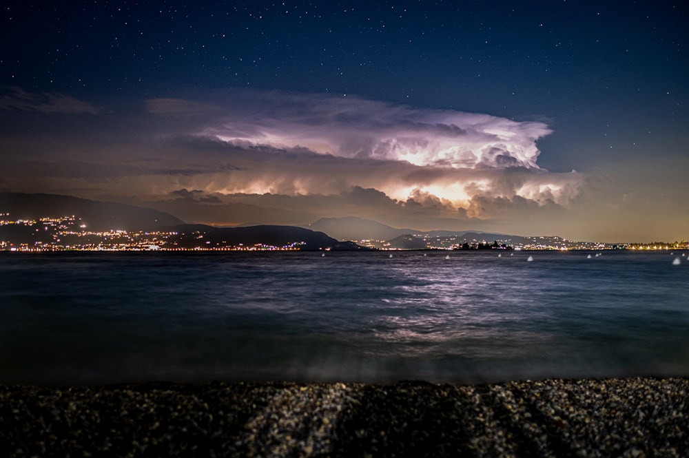 a night time view of a body of water with a city in the background