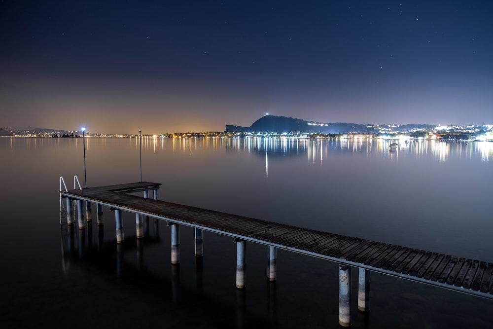 a pier in the middle of a lake at night