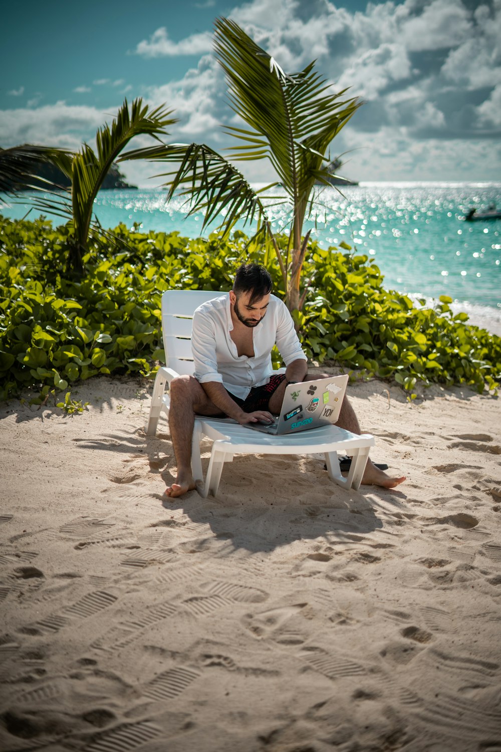 a man sitting on a beach reading a book