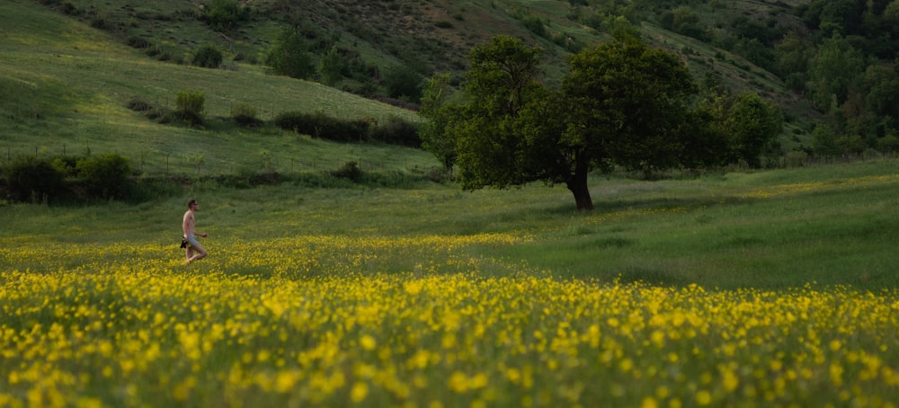 a man running through a field of yellow flowers