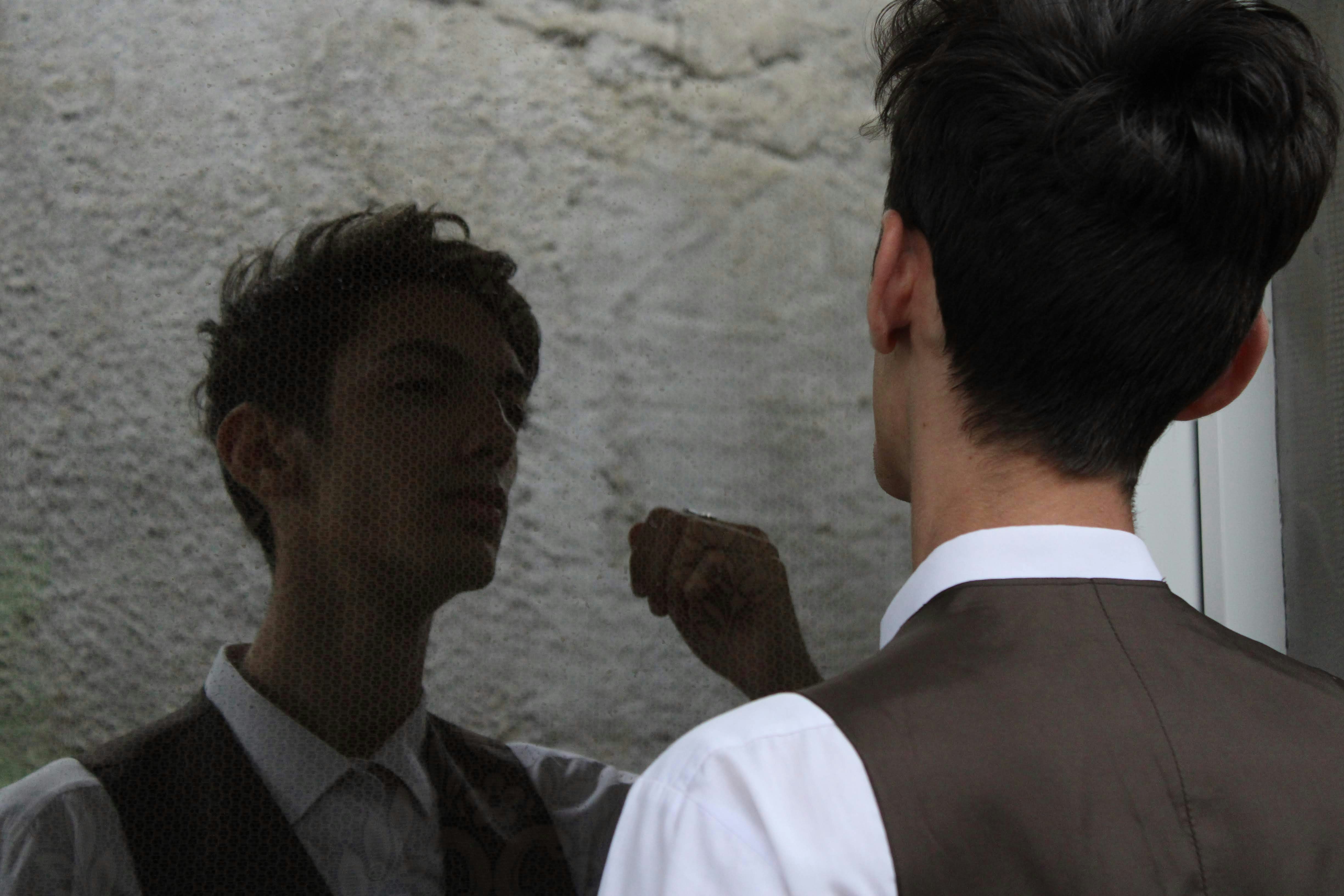 Un hombre parado junto a otro hombre frente a una ventana