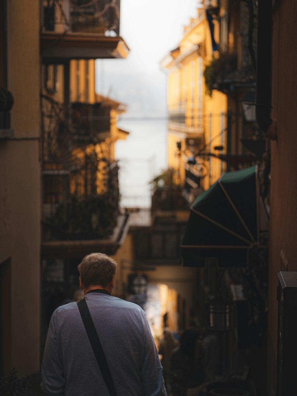 a man walking down a narrow alley way